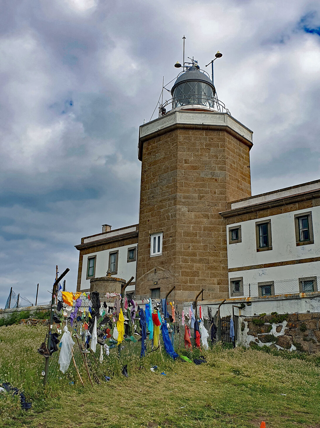 Zaun mit Pilger-Kleidungsstücken am Leuchtturm von Fisterra